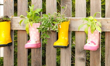 Ein Mädchen mit einem pinken Sommerhut und langen Haaren grinst in die Kamera